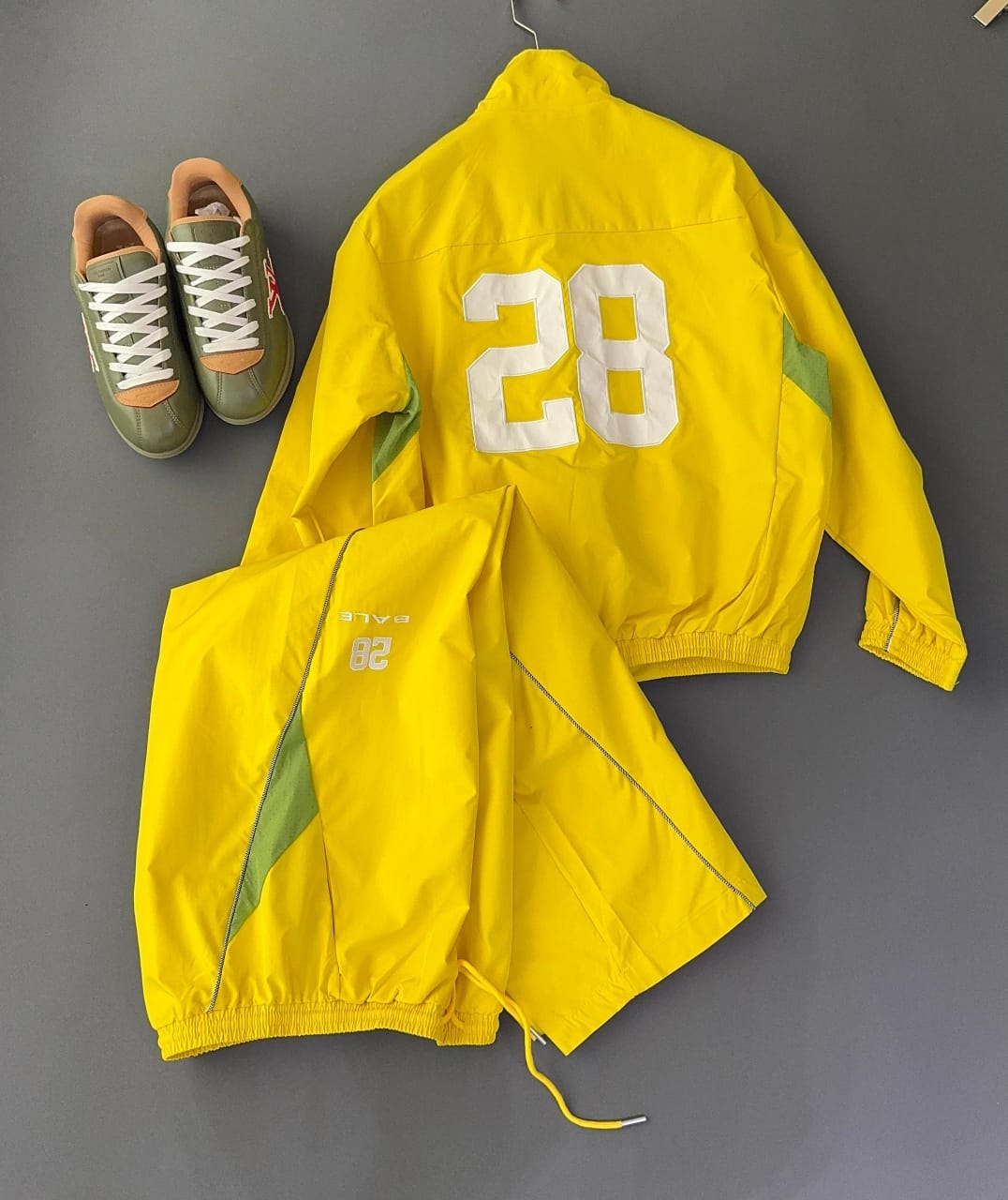 Yellow Bale two-piece tracksuit back view with white 28 graphic and green side panels, styled with green shoes.