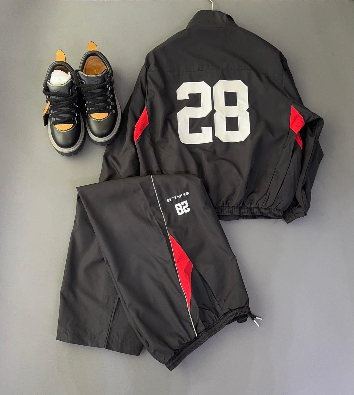 Black Bale two-piece tracksuit back view with large white 28 graphic and red accents, styled with black shoes.