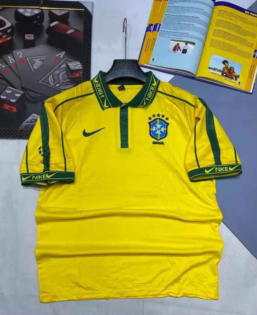 Yellow Nike Brazil football jersey on hanger with background items.