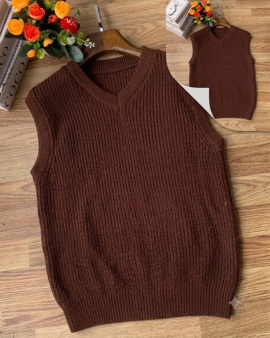 Brown ribbed V-neck armless cardi on wooden floor with floral arrangement.