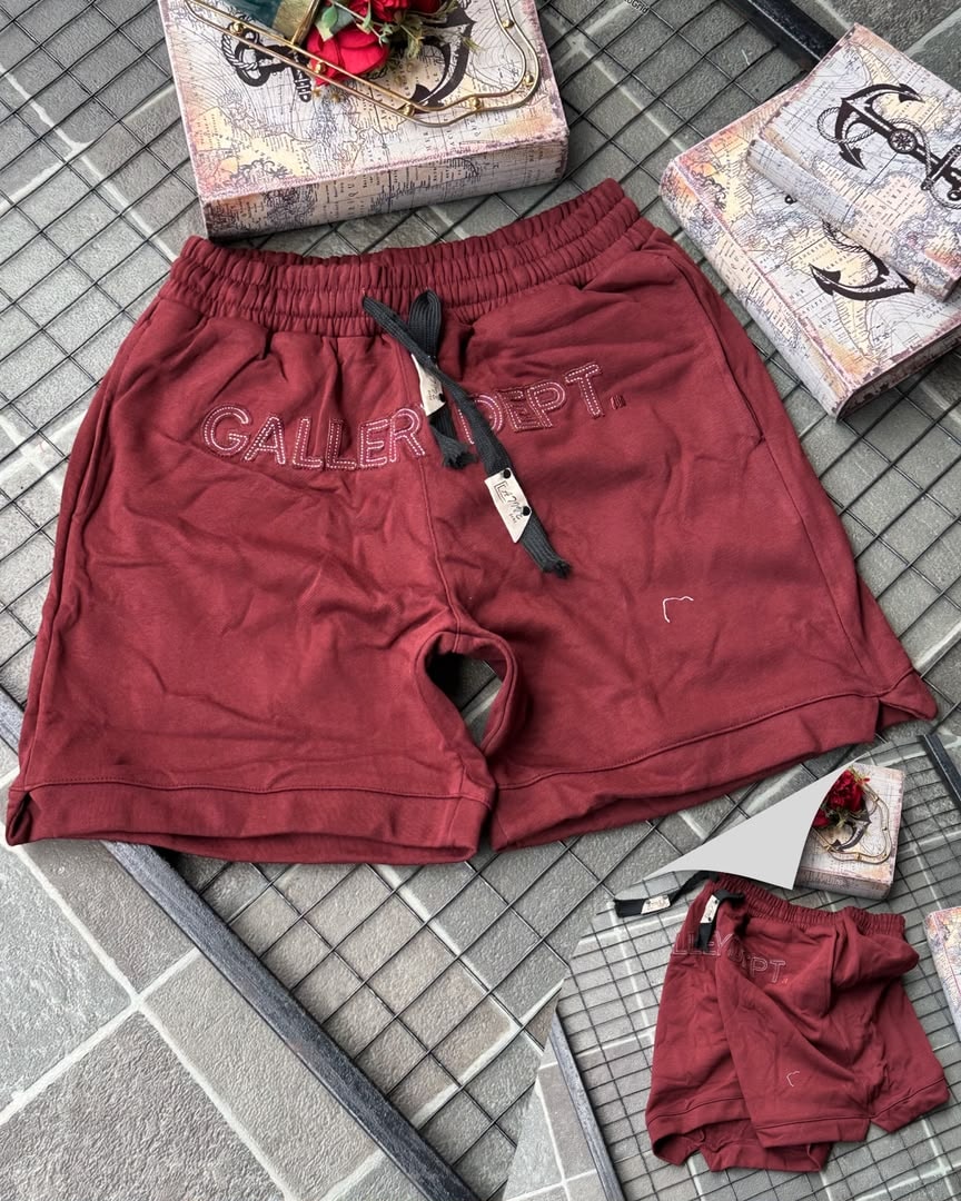 Burgundy Gallery Dept. embroidered fleece shorts on tiled background with props.
