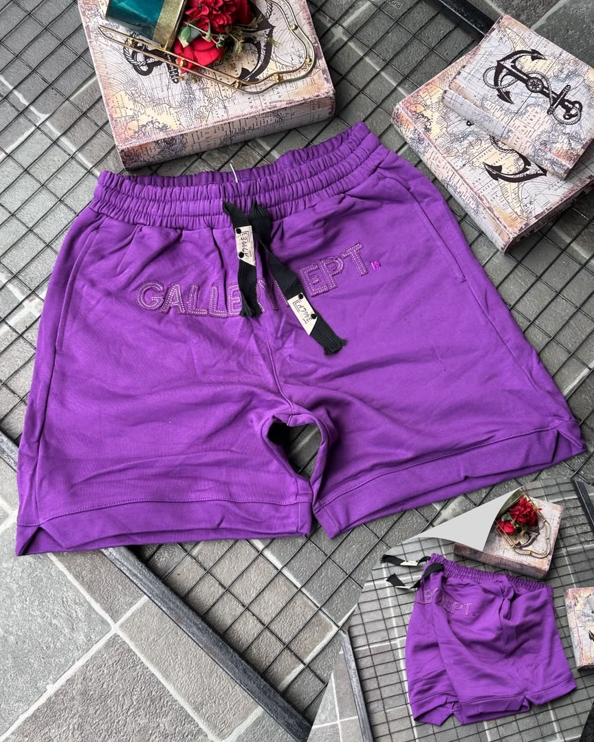 Purple Gallery Dept. embroidered fleece shorts on tiled background with props.