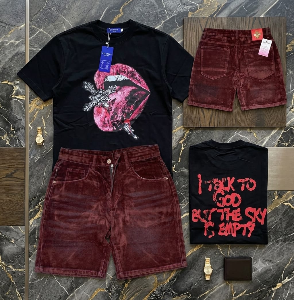 Black t-shirt with pink lips cross graphic, maroon velvet shorts, and folded back view showing red text print, styled with accessories on marble.