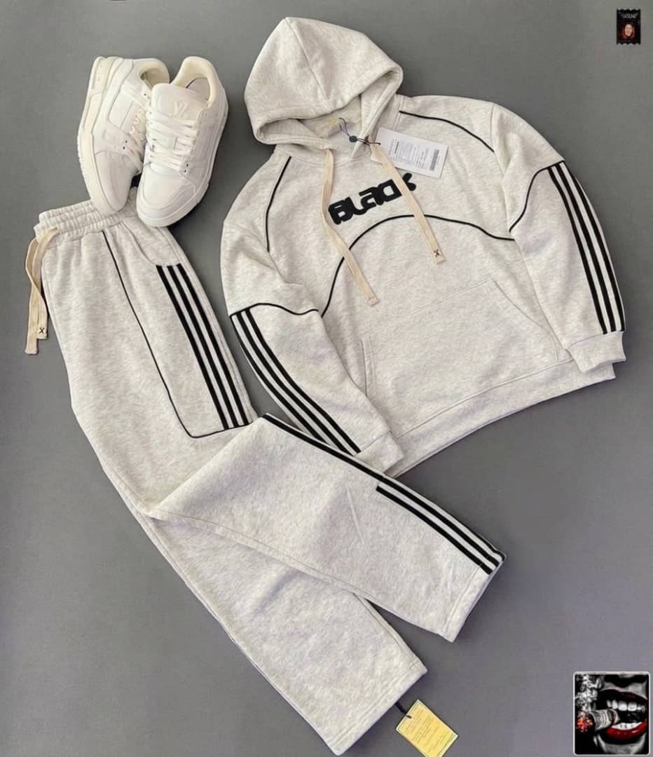 Light gray hoodie with black BLACK graphic and stripes on sleeves and pants, styled with white sneakers.