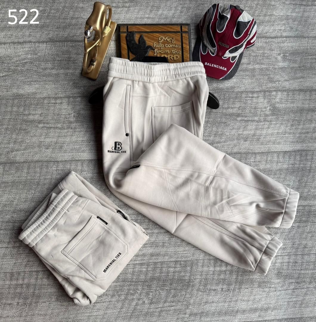 Cream joggers with Material Ties logo, shown in full front view and folded back pocket perspective.