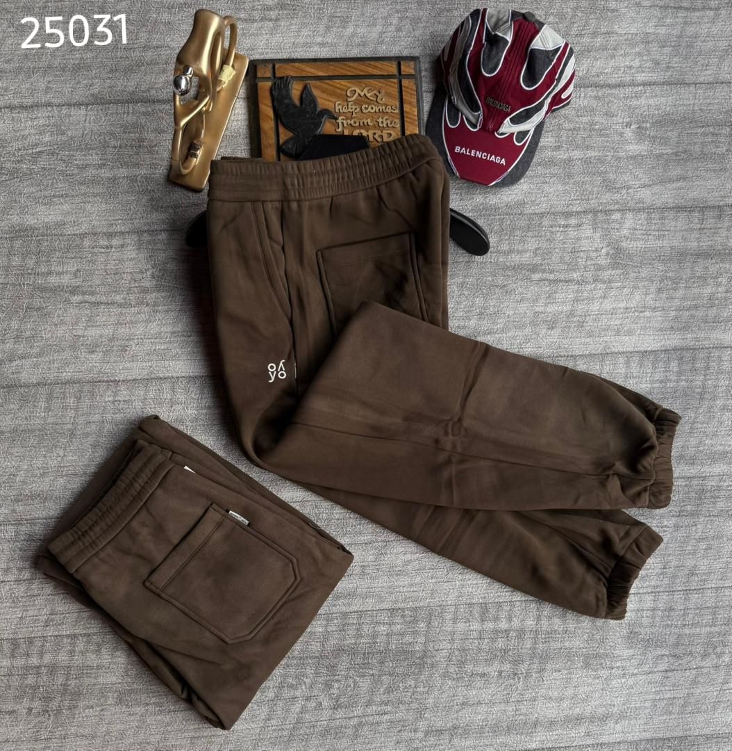 Brown joggers with white logo on leg, shown laid flat and folded to highlight back pocket.