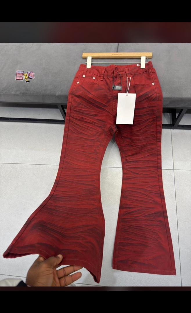 Red ruched flare jeans held up showing flare and wrinkled texture.