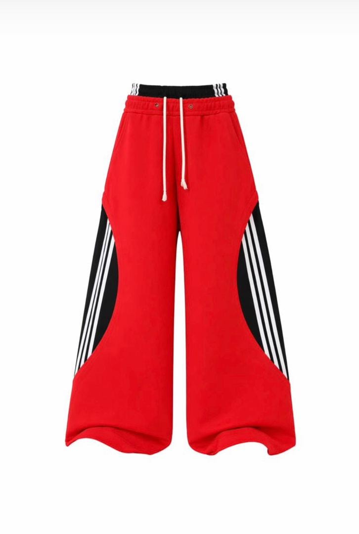 Red wide-leg trousers with black and white side stripes.