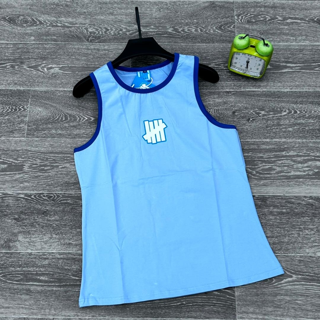 Light blue armless tank top with blue trim and white logo on chest, flat lay view.