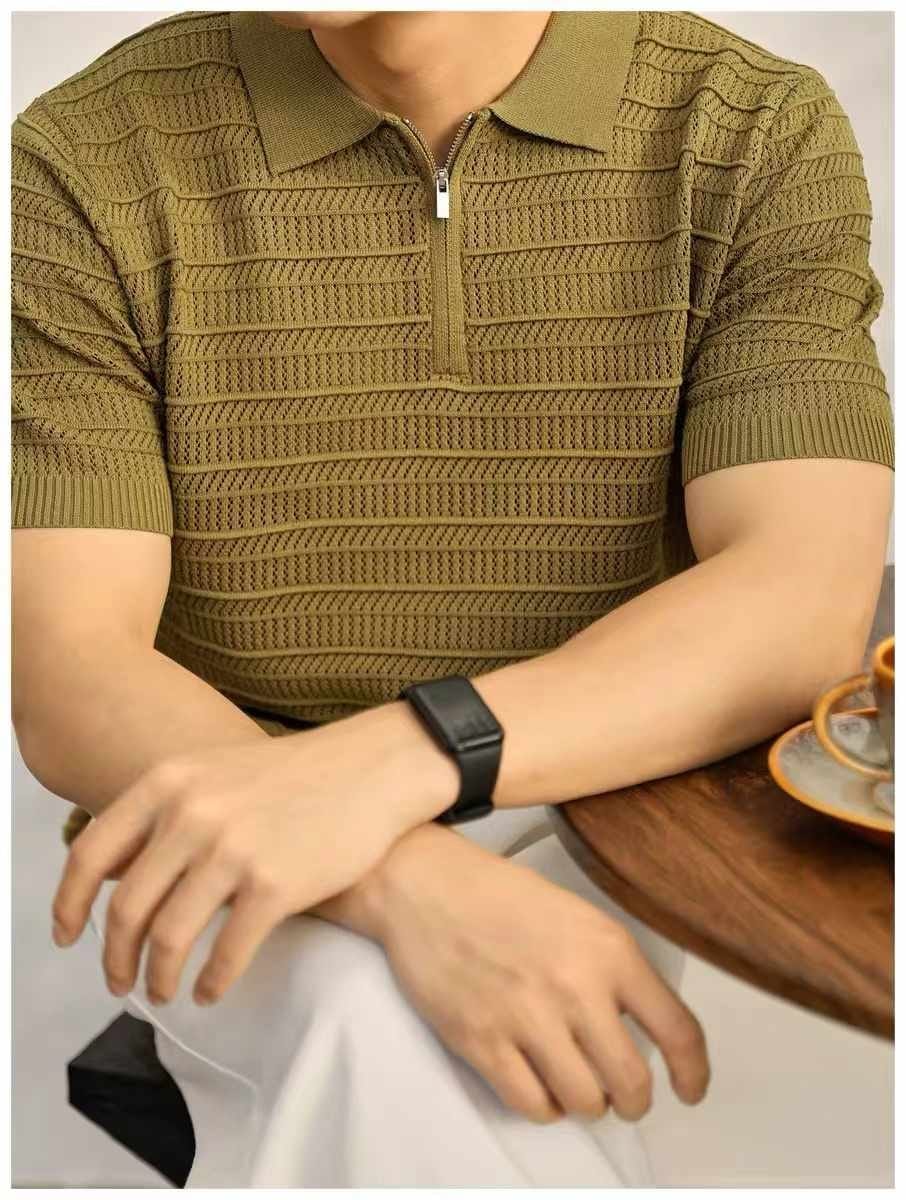 Man wearing olive green textured knit polo shirt at table.