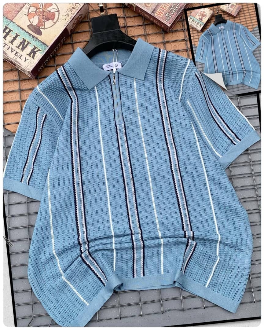 Light blue striped knitted zip polo shirt on hanger over grid.