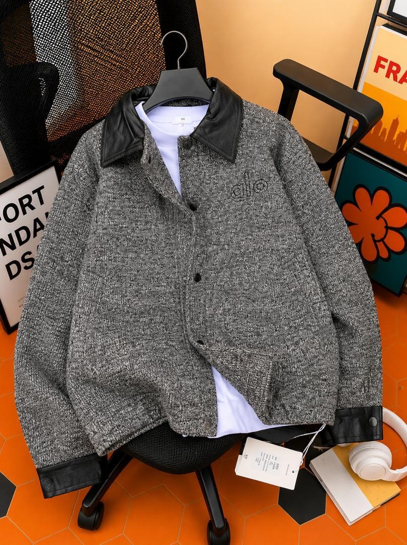 Gray bouclé jacket with black leather collar shown on hanger over white tee.