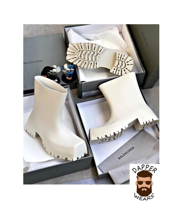 White Balenciaga boots unboxed showing serrated tread sole and luxury packaging.