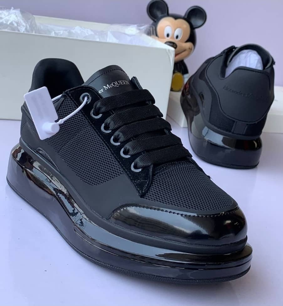 Black Alexander McQueen platform sneakers with thick sole and box.