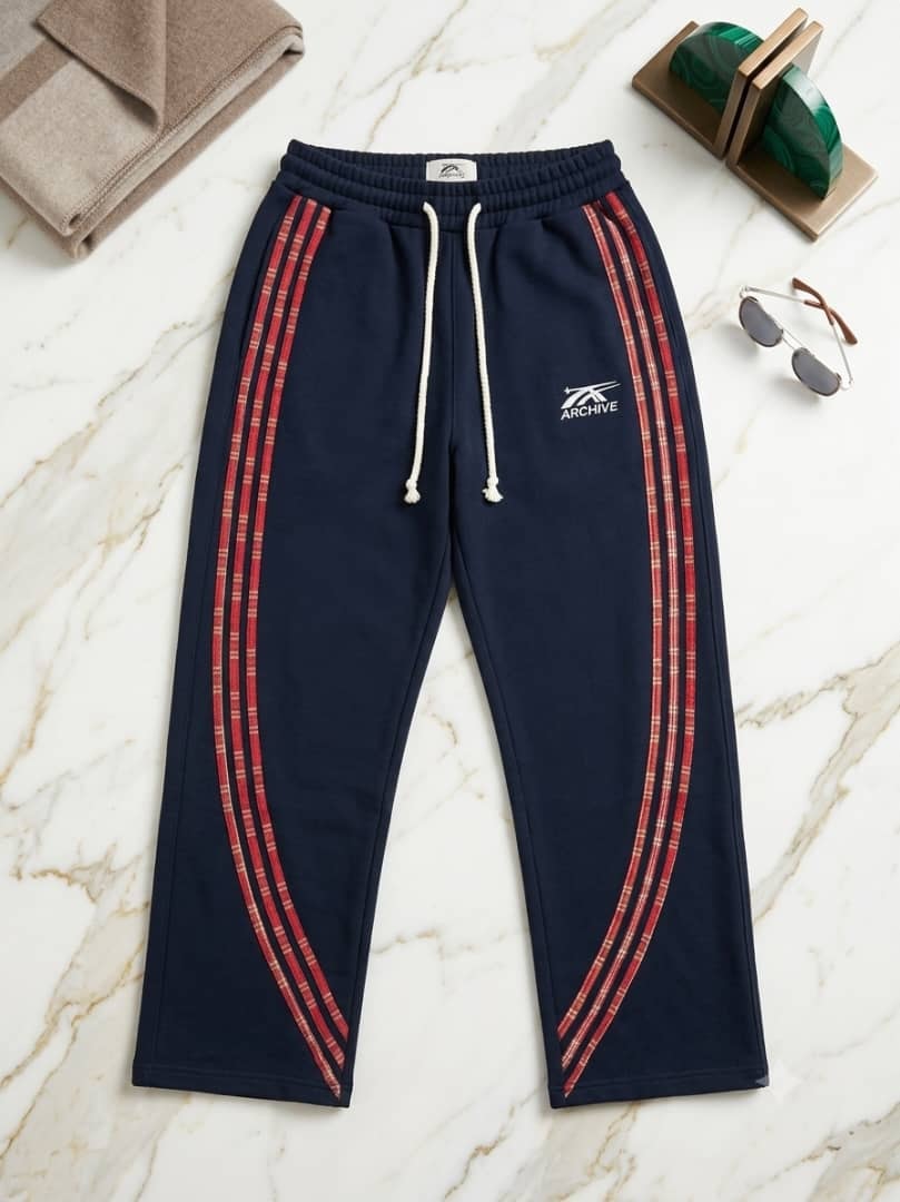 Navy joggers with red plaid side stripes on green marble.