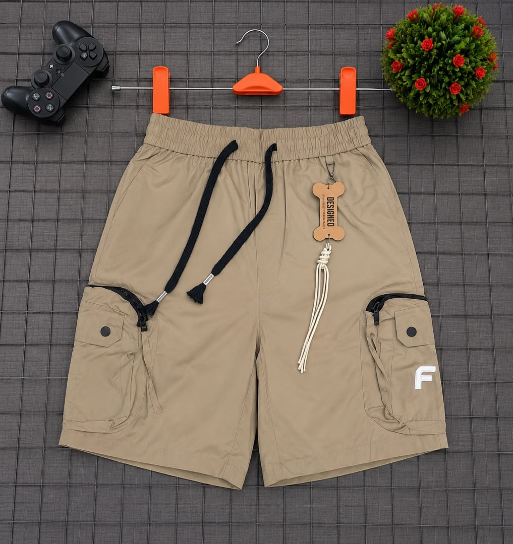 Beige cargo shorts on grid background showing F logo, drawstring and tag.