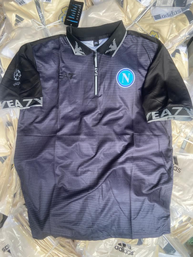 Dark patterned EA7 Napoli soccer jersey with black sleeves and logos.