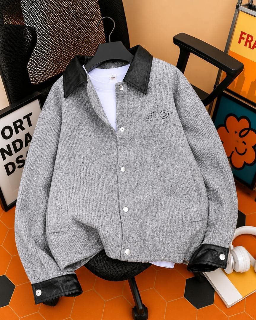 Gray knit jacket with black leather collar, cuffs and 'alo' embroidery over white t-shirt.
