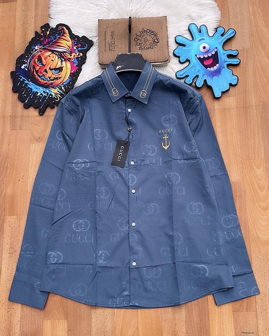 Blue Gucci monogram long sleeve shirt with anchor embroidery laid flat.
