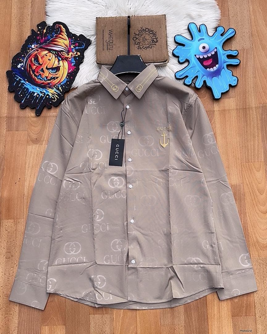 Beige Gucci monogram long sleeve shirt with anchor embroidery laid flat.