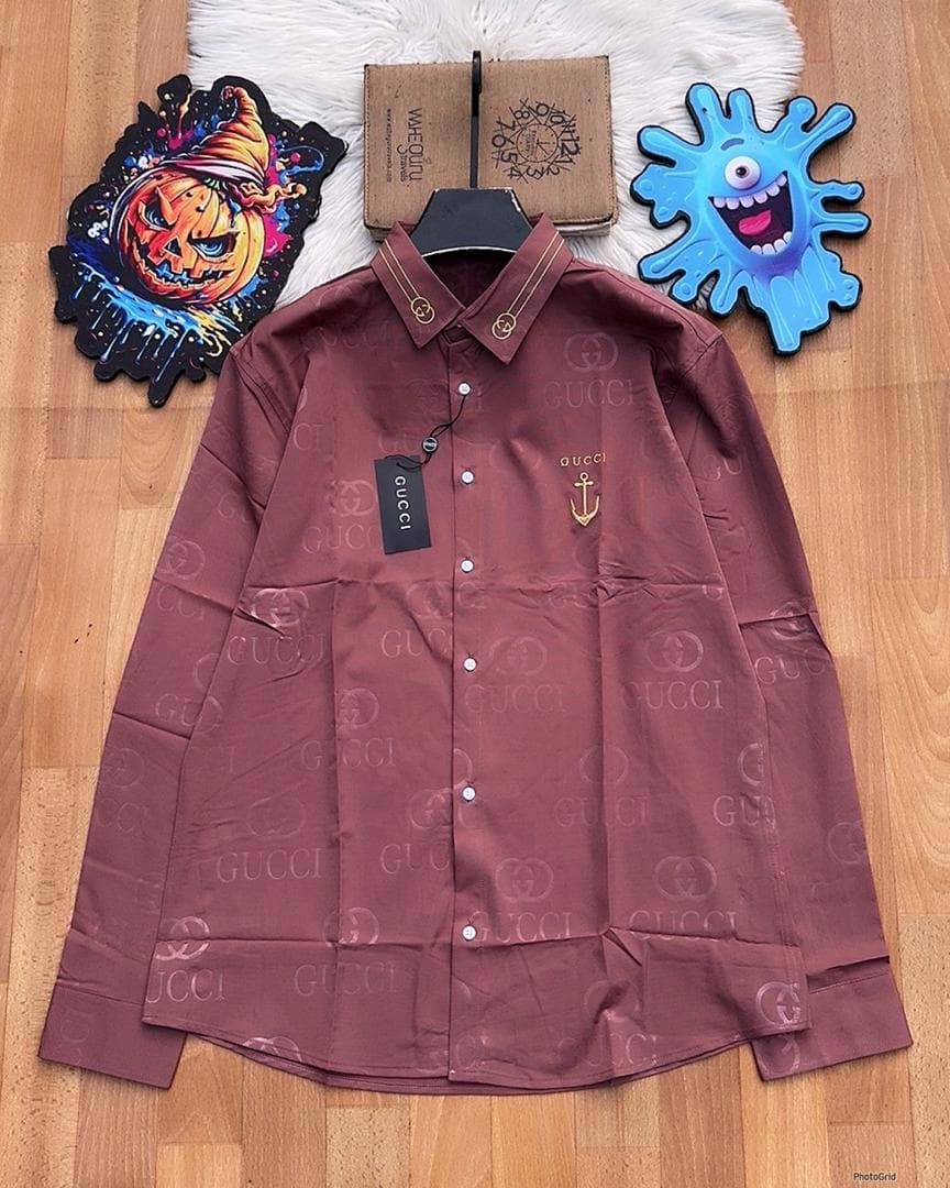 Burgundy Gucci monogram long sleeve shirt with anchor embroidery laid flat.