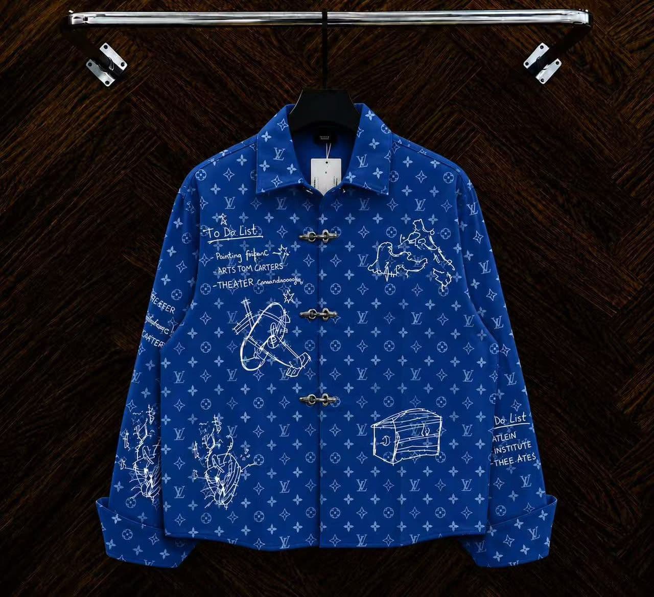 Blue monogram sketch toggle jacket hanging on rack with white drawings.
