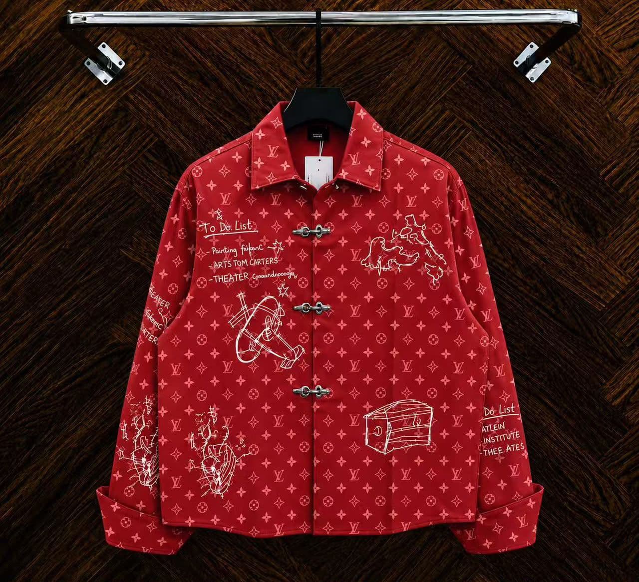Red monogram sketch toggle jacket hanging on rack with white drawings.