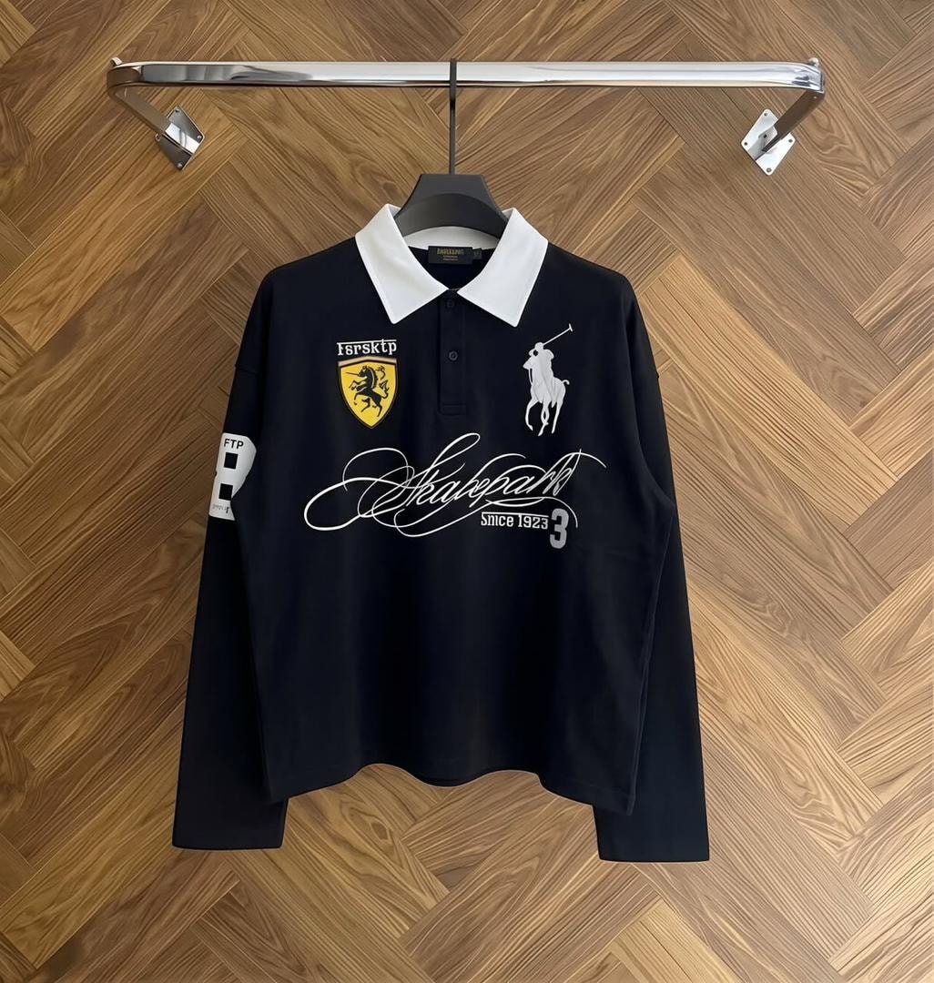 White long sleeve polo shirt with black collar and black graphic prints on chest and sleeve.