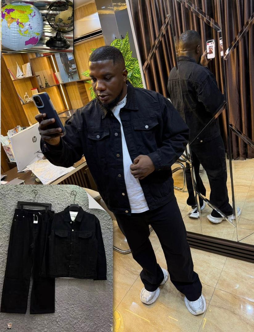Man wearing black denim jacket and pants set with flat lay inset of the two-piece.