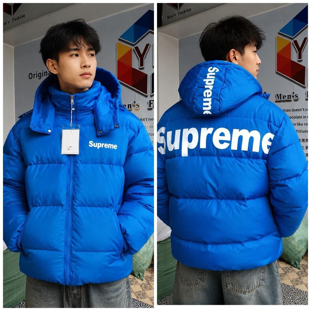 Man modeling bright blue Supreme puffer jacket in front and back views.