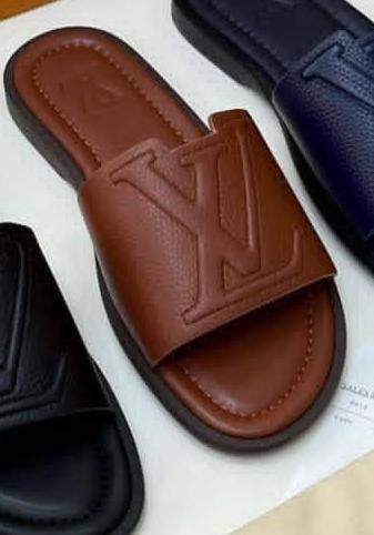 Brown Louis Vuitton slide with large LV logo shown alongside partial views of black and navy versions.