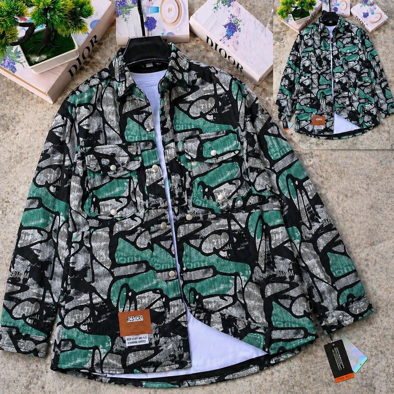 Green black and gray abstract patterned denim jacket on hanger with white layer and inset back image.