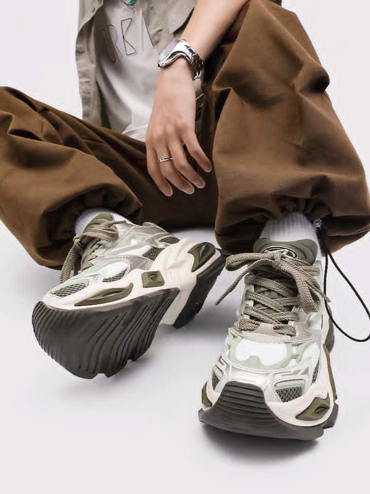 Olive and white chunky wave runner sneakers worn with brown cargo pants in studio.