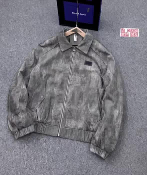 Gray Omega distressed bomber jacket hanging on wooden hanger against gray background.