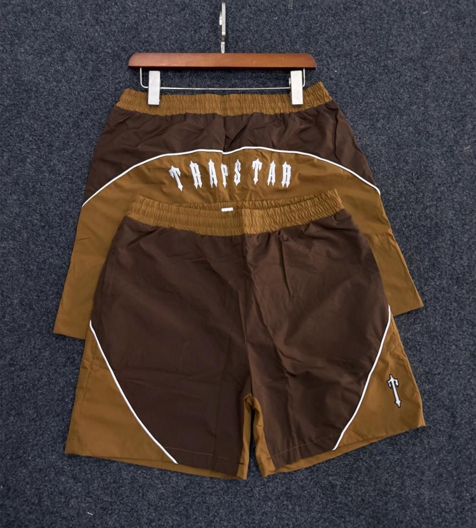 Brown Trapstar logo colorblock shorts from rear view on hanger.