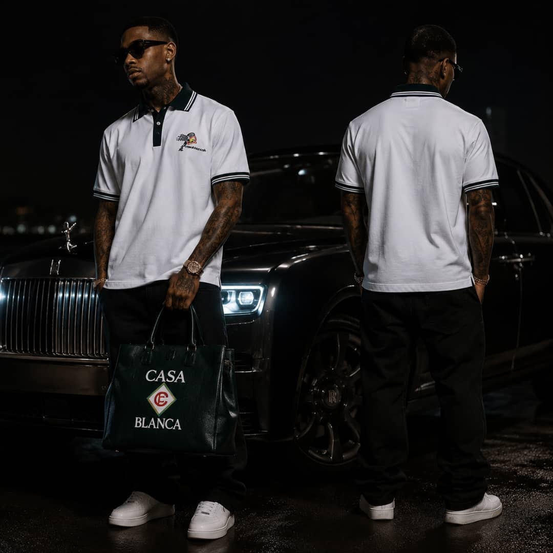 Man wearing white polo shirt with contrast trim standing by luxury car.