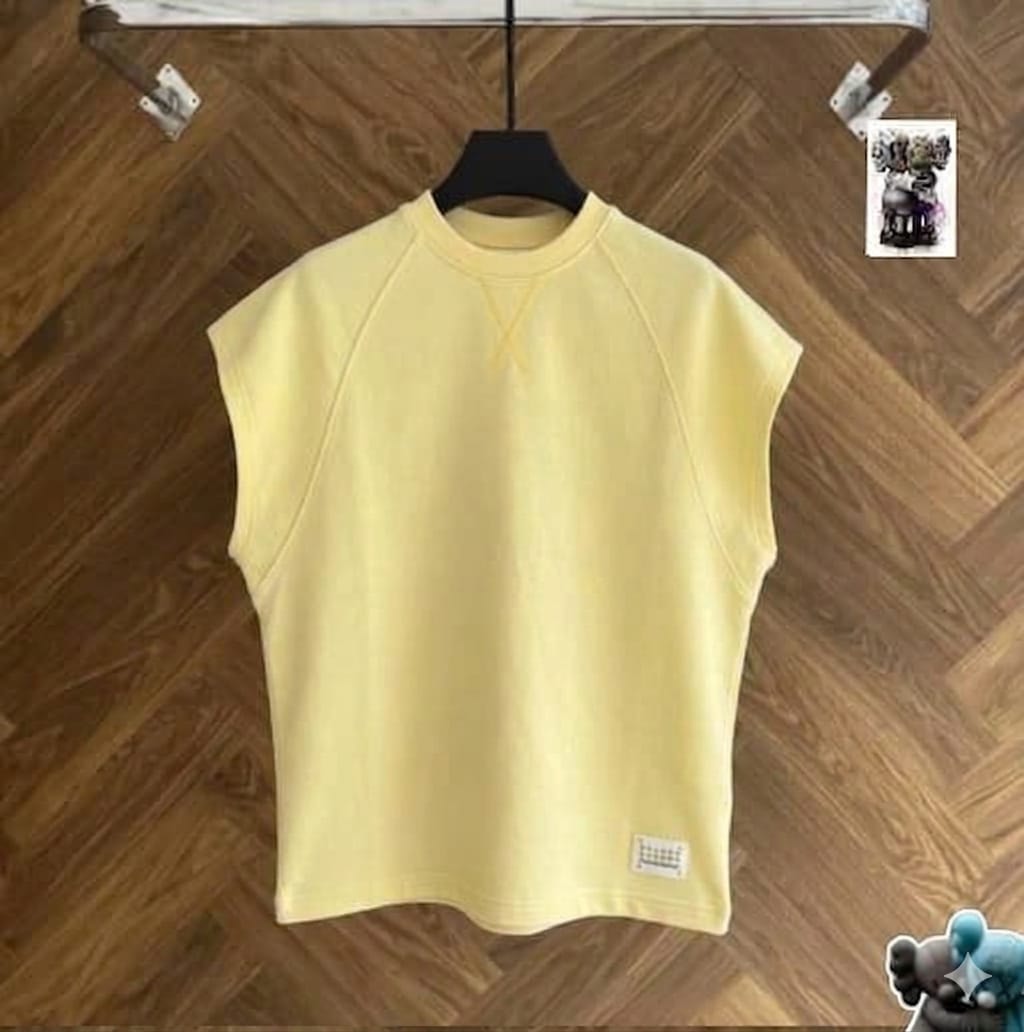 Yellow raglan armless top on black hanger against wood floor.