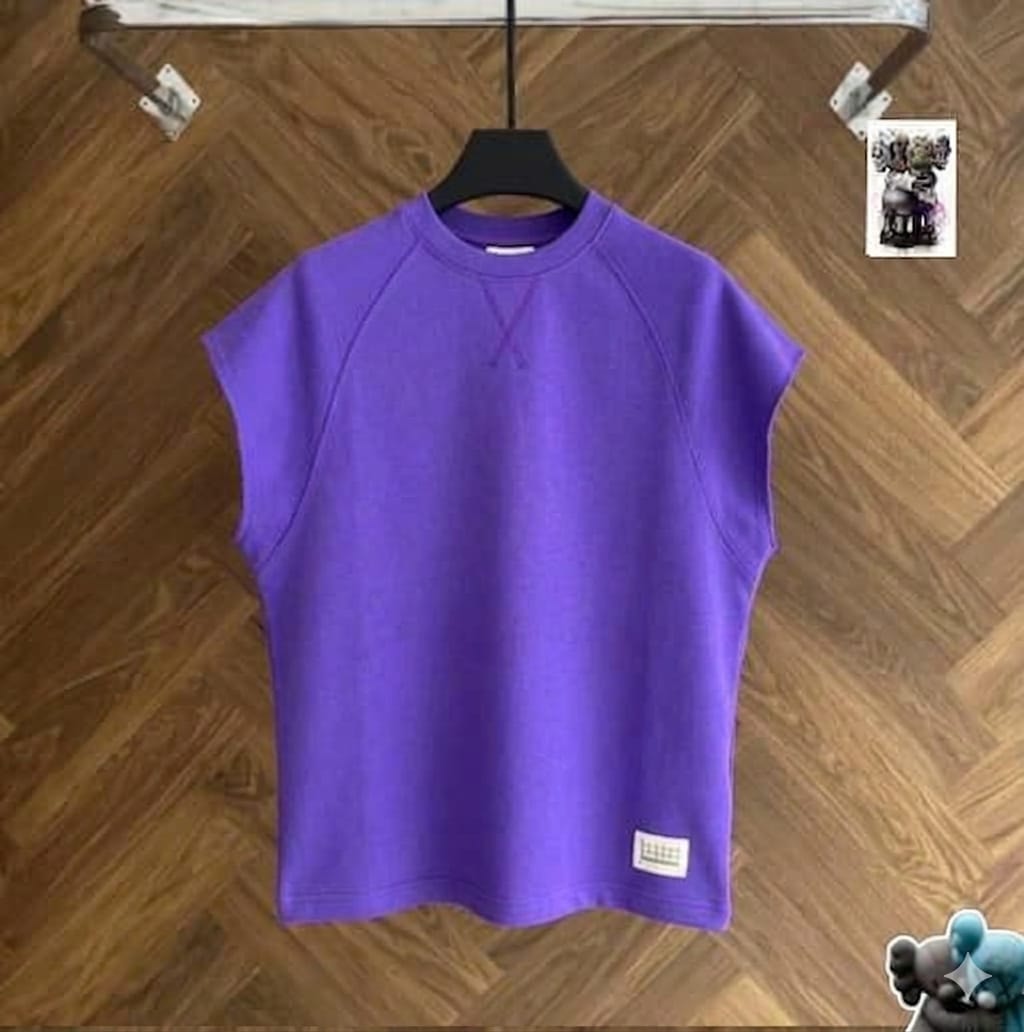 Purple raglan armless top on black hanger against wood floor.
