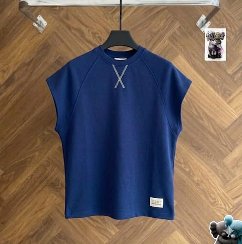 Navy raglan armless top on black hanger against wood floor.