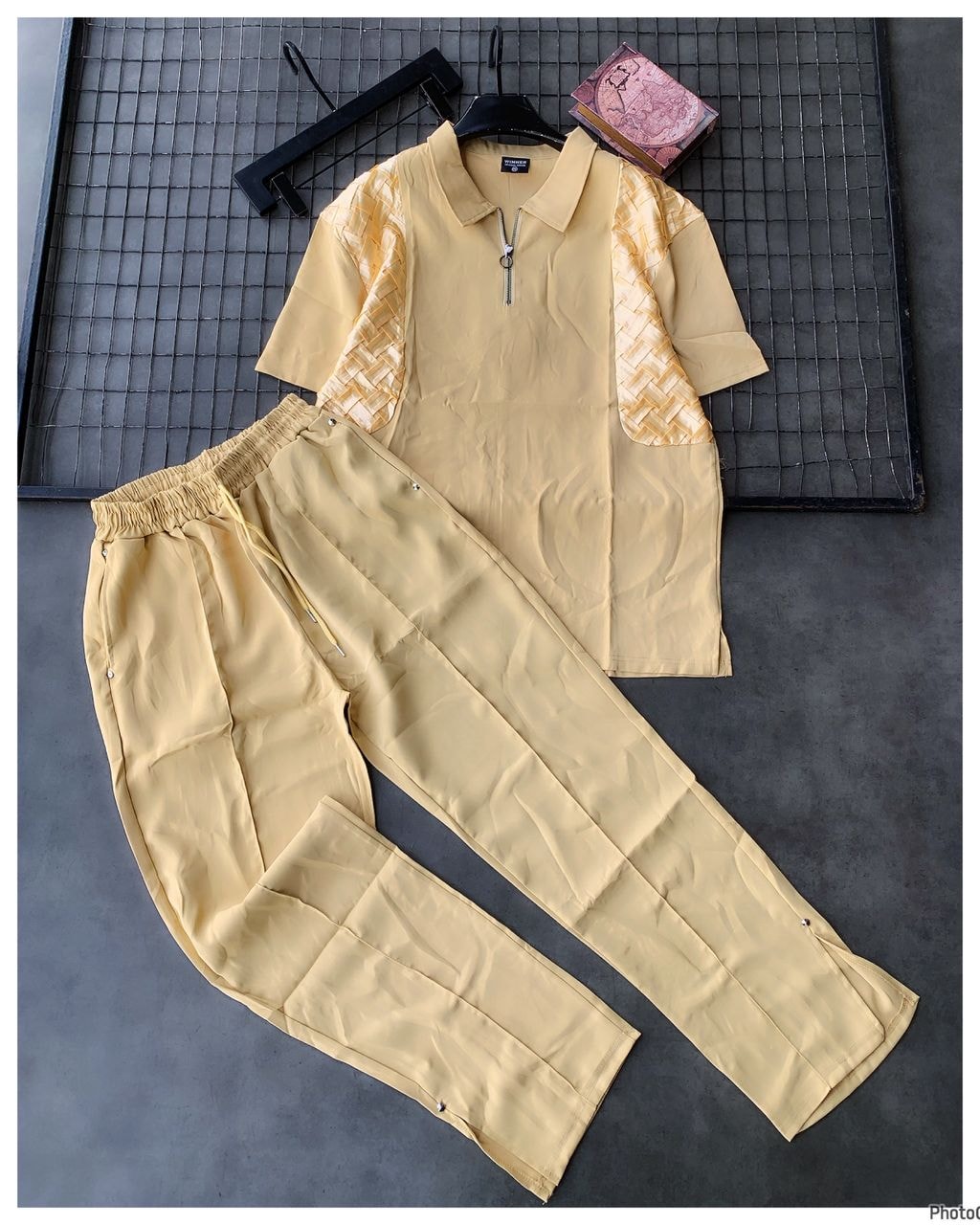 Cream unisex two-piece set with zip collar top featuring woven shoulder panels and coordinating trousers.