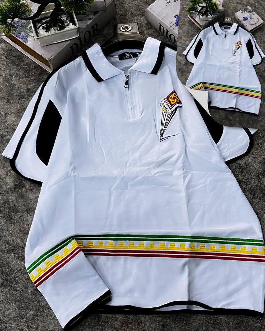 White polo shirt with black contrast trim, striped hem details, and embroidered column design on chest.