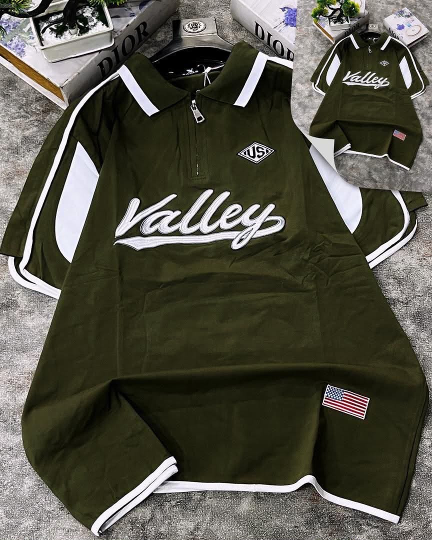 Olive green Valley script polo shirt displayed with white contrast stripes on sleeves and collar plus chest embroidery.