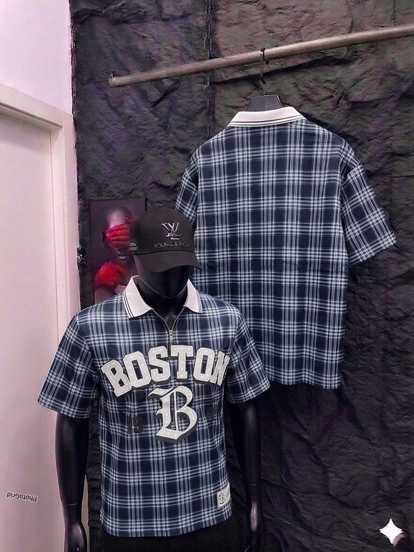 Mannequin in navy plaid polo shirt with Boston graphic, back view hanging on rack.
