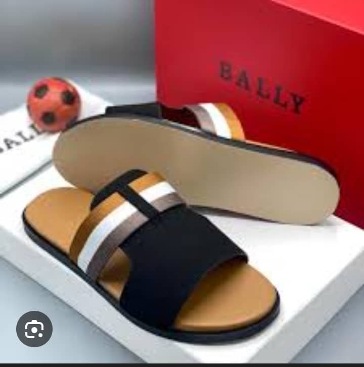 Black striped Bally sandals with red box and accessories on display.
