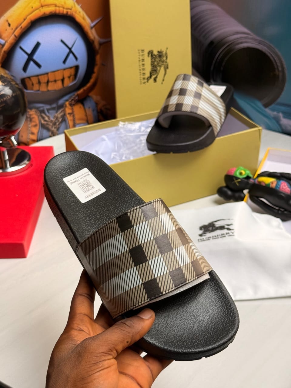 Burberry checkered slides in beige and brown plaid pattern.