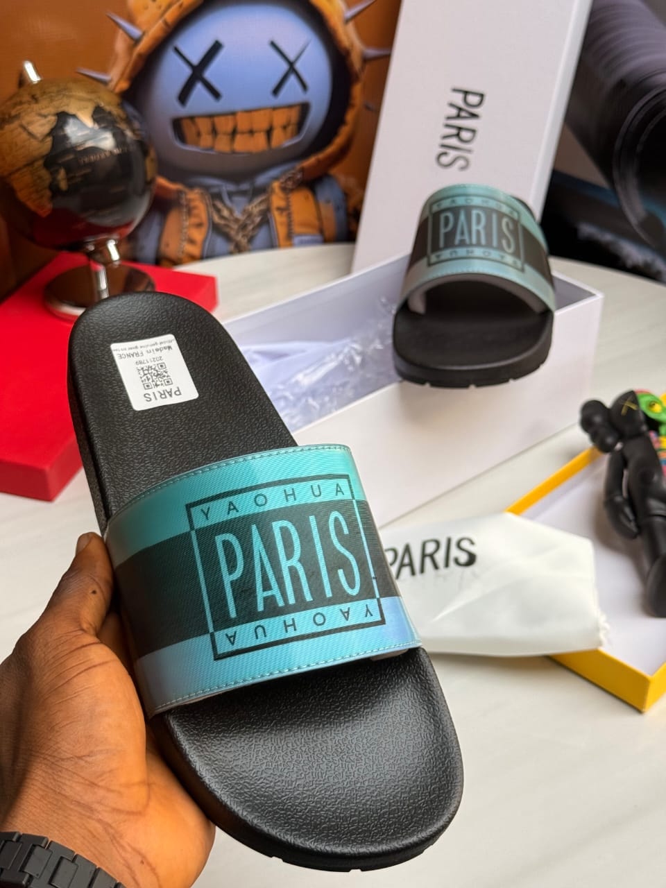 Paris logo slides with teal gradient strap and black sole.