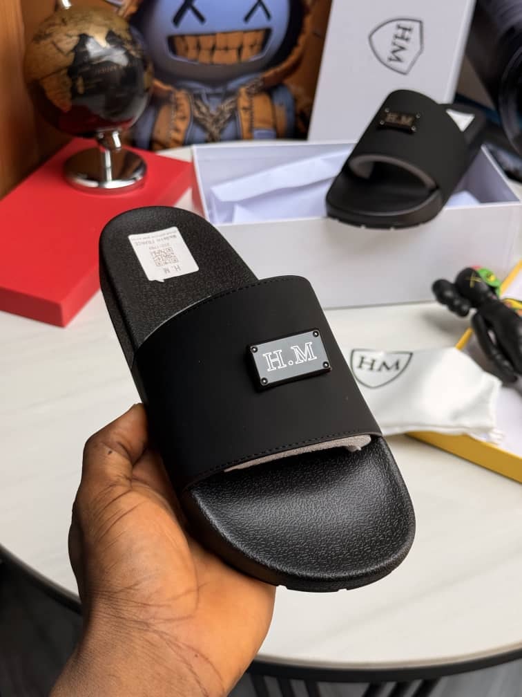 Black H.M slide held in hand highlighting metal plate logo and packaging.