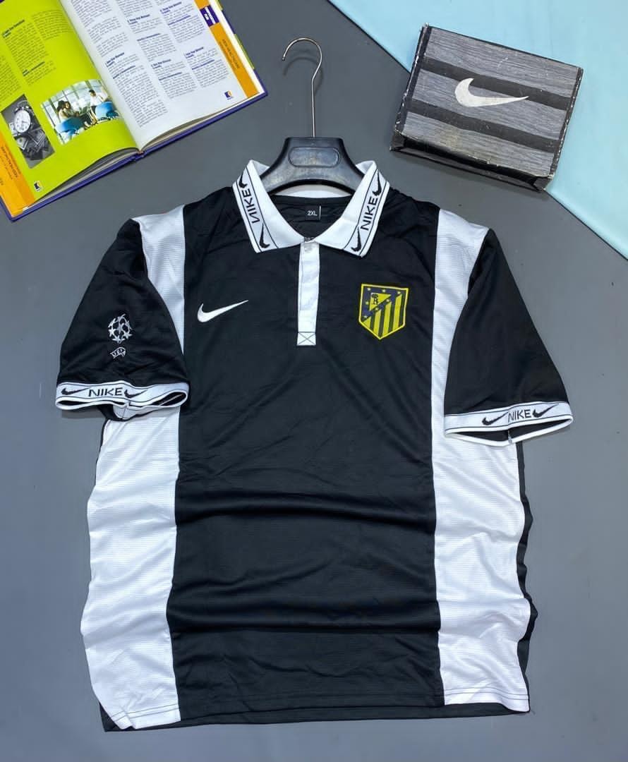 Black and white Nike Atletico Madrid soccer jersey on hanger with crest.
