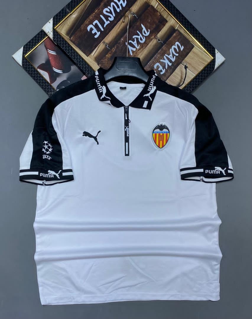 White and black Puma Valencia soccer jersey on hanger with crest and logos.