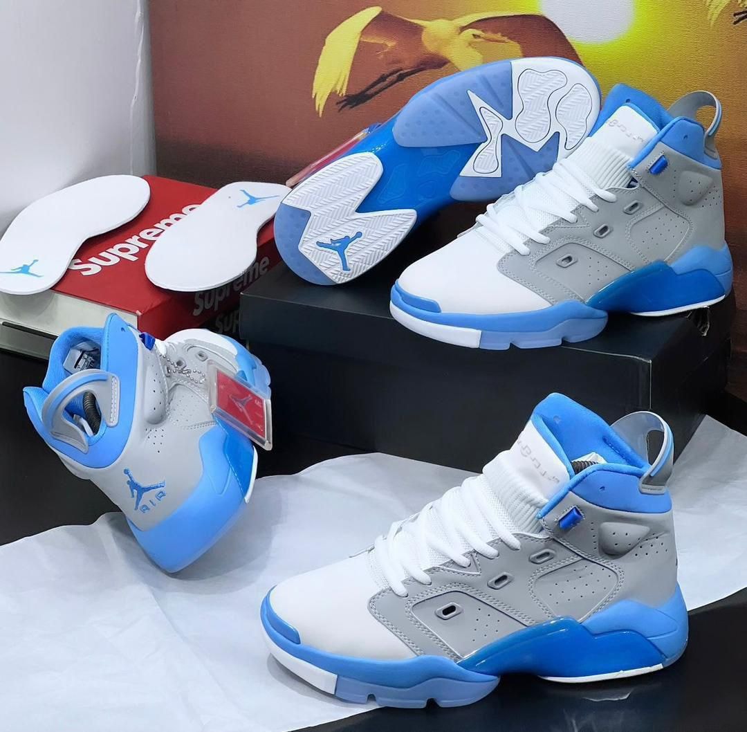 Blue gray and white Jordan 6 high sneakers displayed with insoles and box.